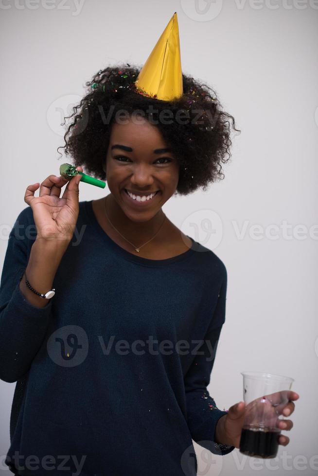 donna nera in cappello da festa che soffia nel fischio foto