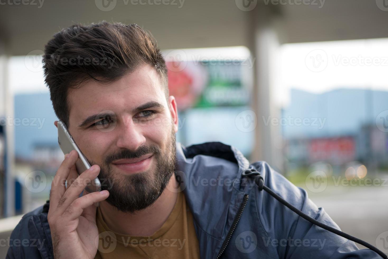 bello giovane casuale attività commerciale uomo con barba utilizzando cellula Telefono foto