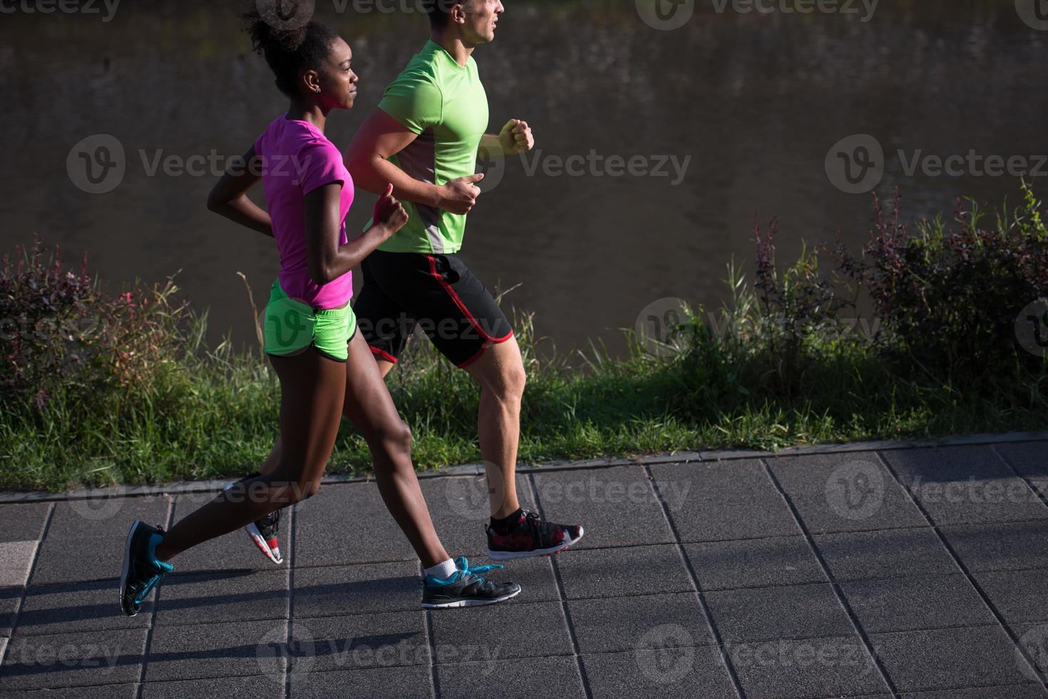 giovane sorridente multietnico coppia jogging nel il città foto