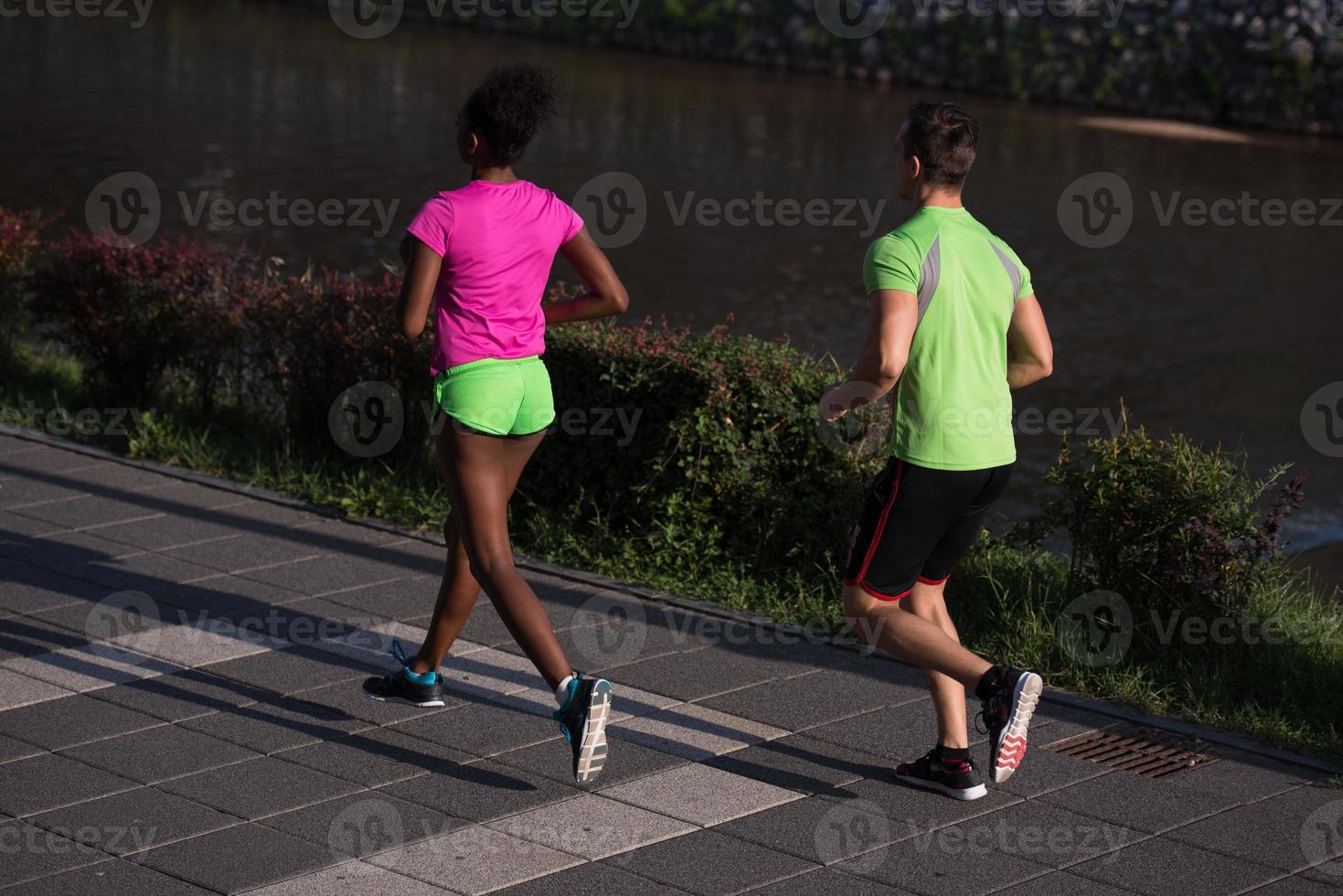 giovane sorridente multietnico coppia jogging nel il città foto