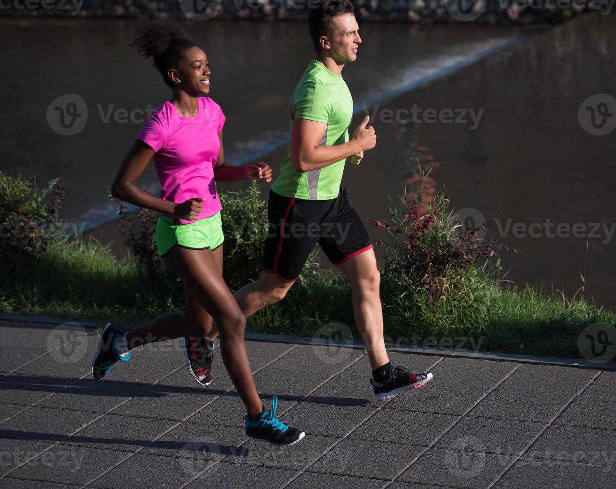 giovane sorridente multietnico coppia jogging nel il città foto