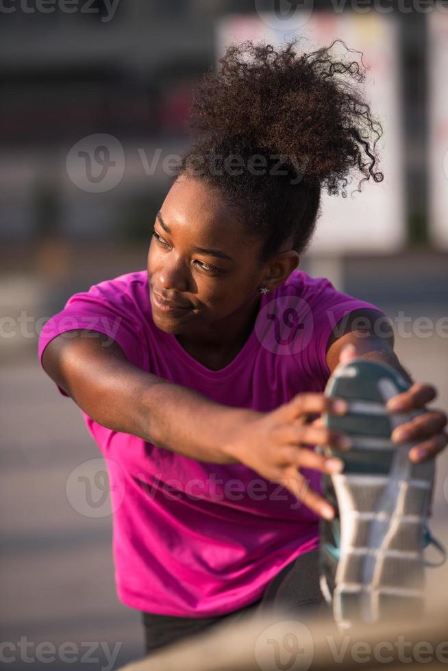 africano americano donna fare riscaldamento su e allungamento foto