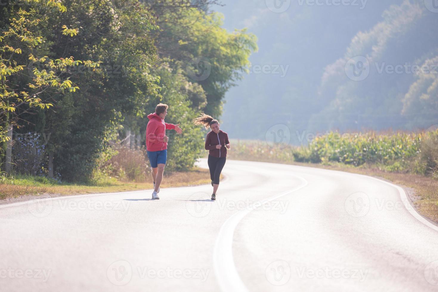 giovane coppia fare jogging lungo una strada di campagna foto