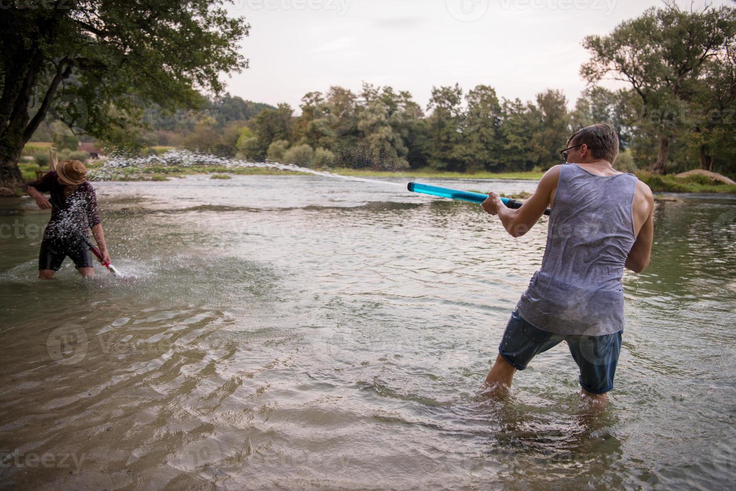 giovane uomini avendo divertimento con acqua pistole foto