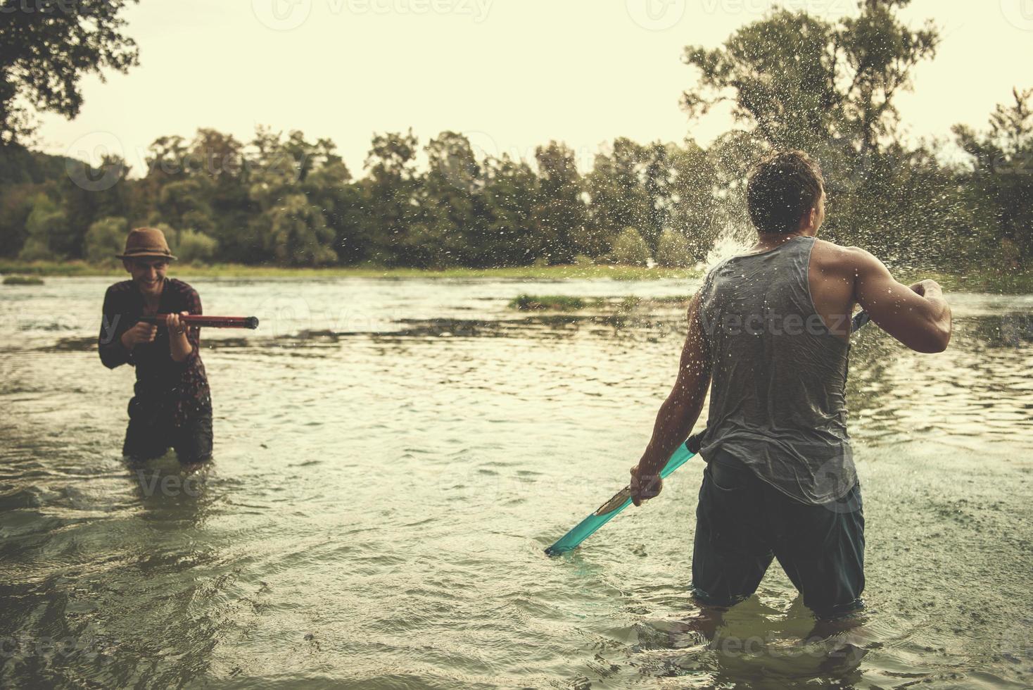 giovane uomini avendo divertimento con acqua pistole foto