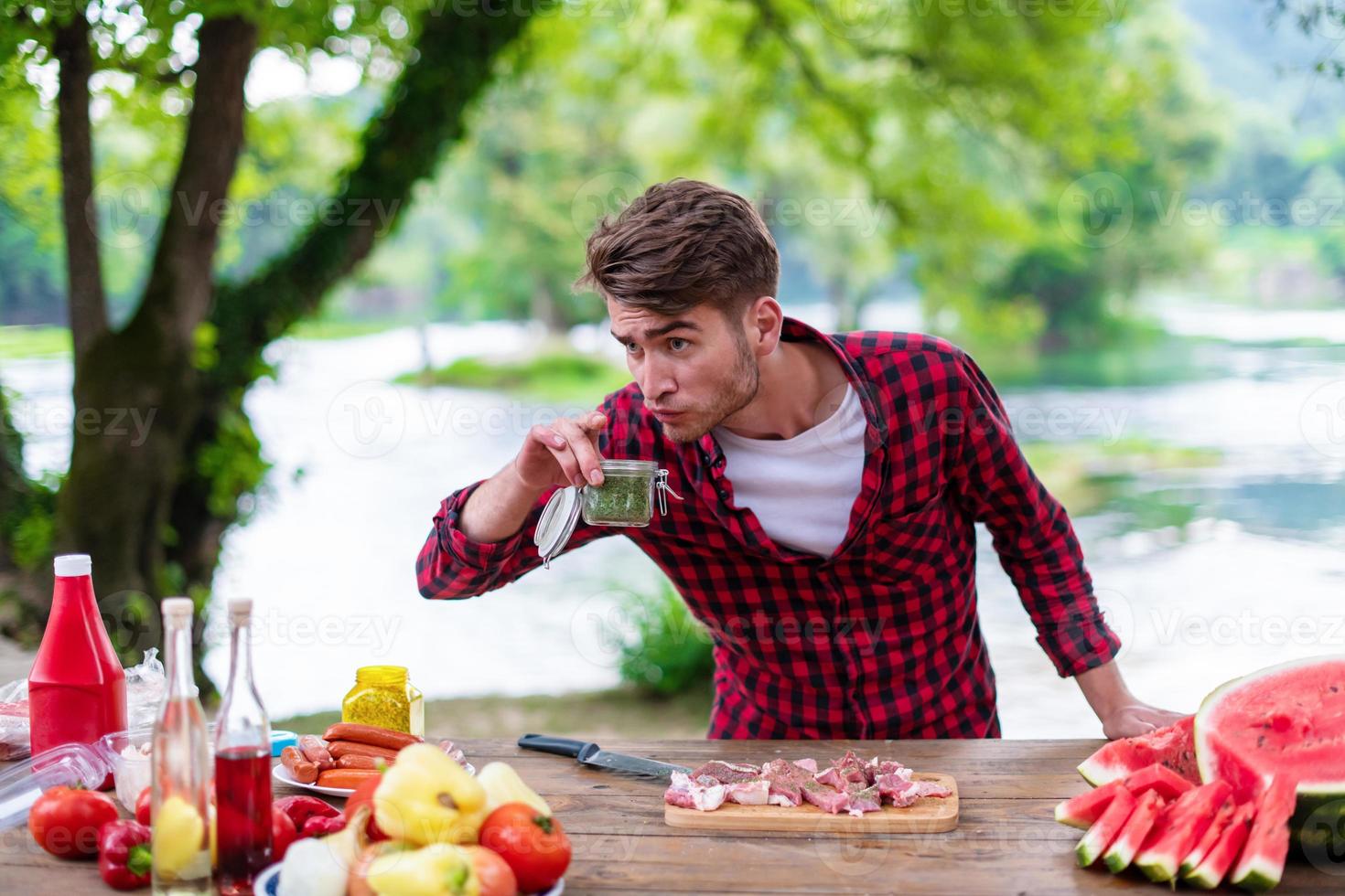 uomo mettendo spezie su crudo carne per barbecue griglia foto