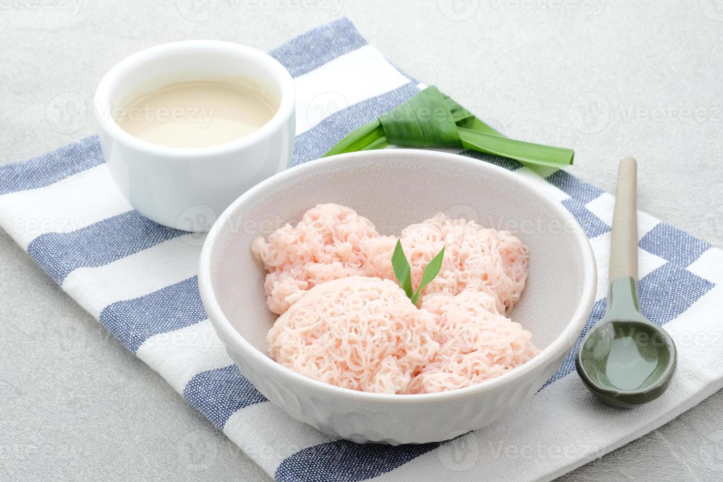 kue putu maya è tradizionale indonesiano merenda fatto a partire dal riso Farina filoni arricciato su in un' sfera, servito con Noce di cocco latte e palma zucchero. foto