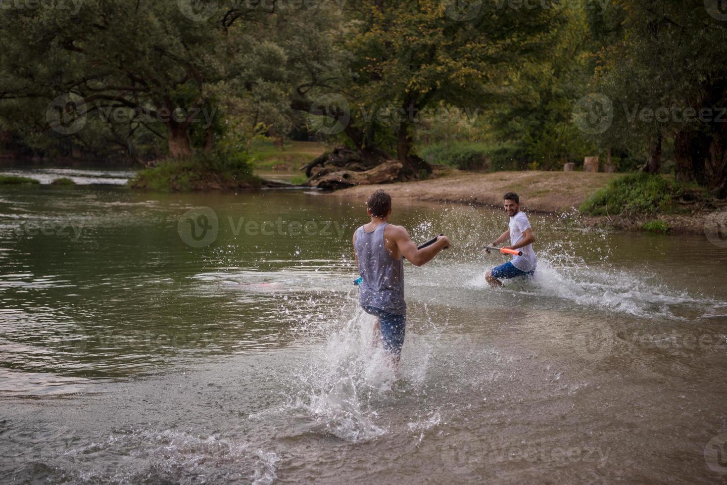 giovane uomini avendo divertimento con acqua pistole foto