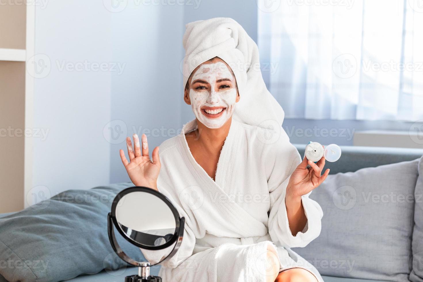 giovane donna con detergente maschera su sua viso a casa. pelle cura. donna applicando bellezza maschera, chiudi su. così Bellissima. avvicinamento di ragazza con bellezza maschera su sua viso guardare nel specchio. foto