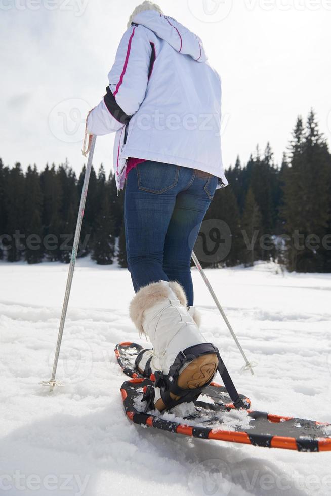 coppia divertendosi e camminando con le racchette da neve foto