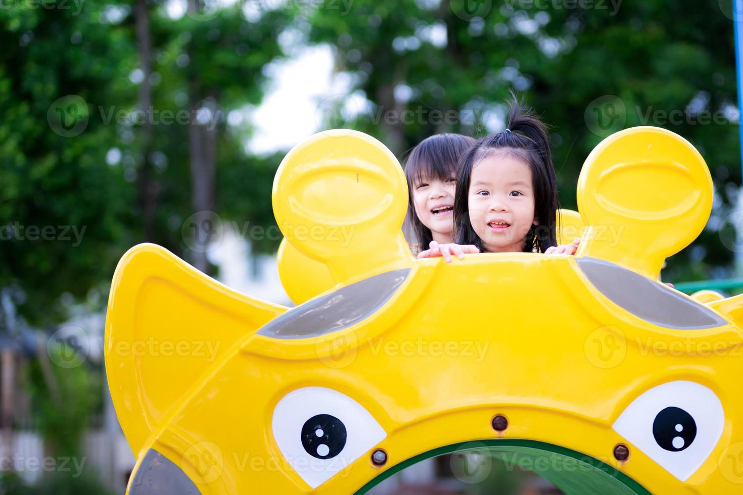 Due ragazze scalato su il tubo e sat e rideva. bambini siamo felice, sorridente, dolce e luminosa. asiatico bambini anziano 3 - 5 anni. foto