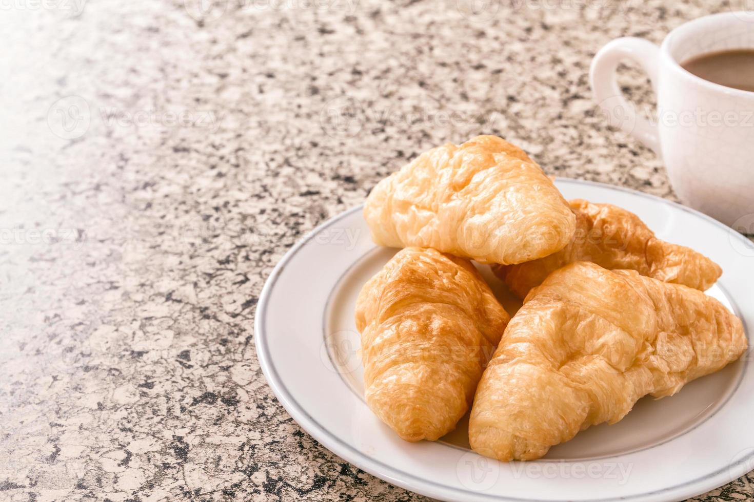 prima colazione con tazza di caffè, brioche su il tavolo. foto