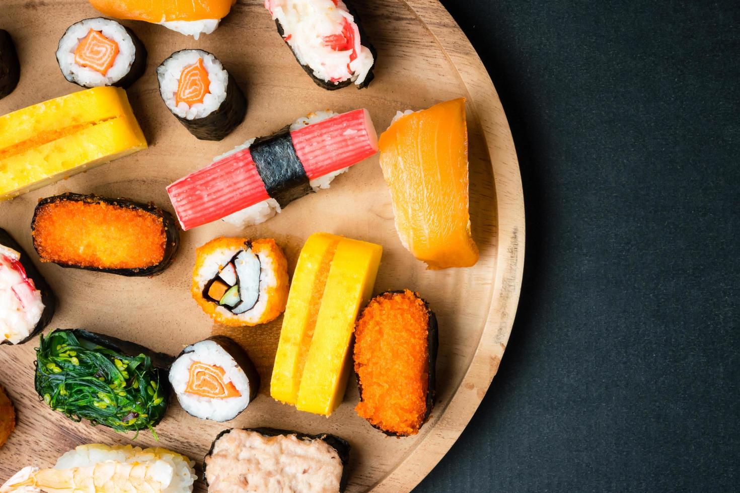 superiore Visualizza di Sushi impostato su di legno piatto su nero sfondo, giapponese cibo. gratuito spazio per testo foto