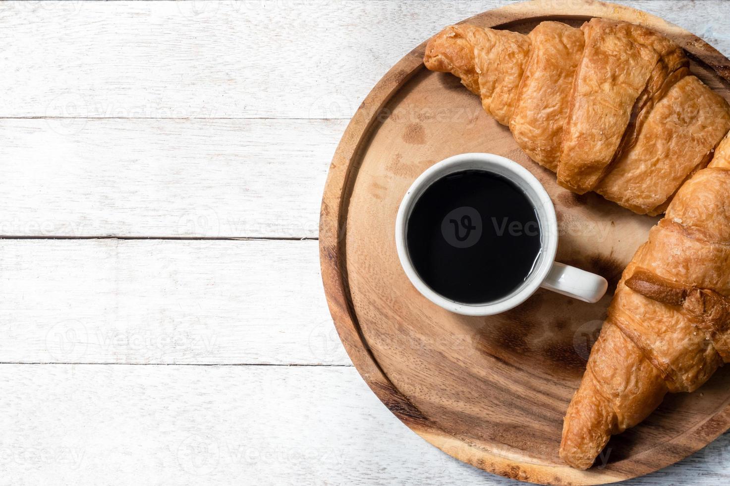 superiore Visualizza di Cornetti e caffè su di legno tavolo sfondo. gratuito spazio per testo foto