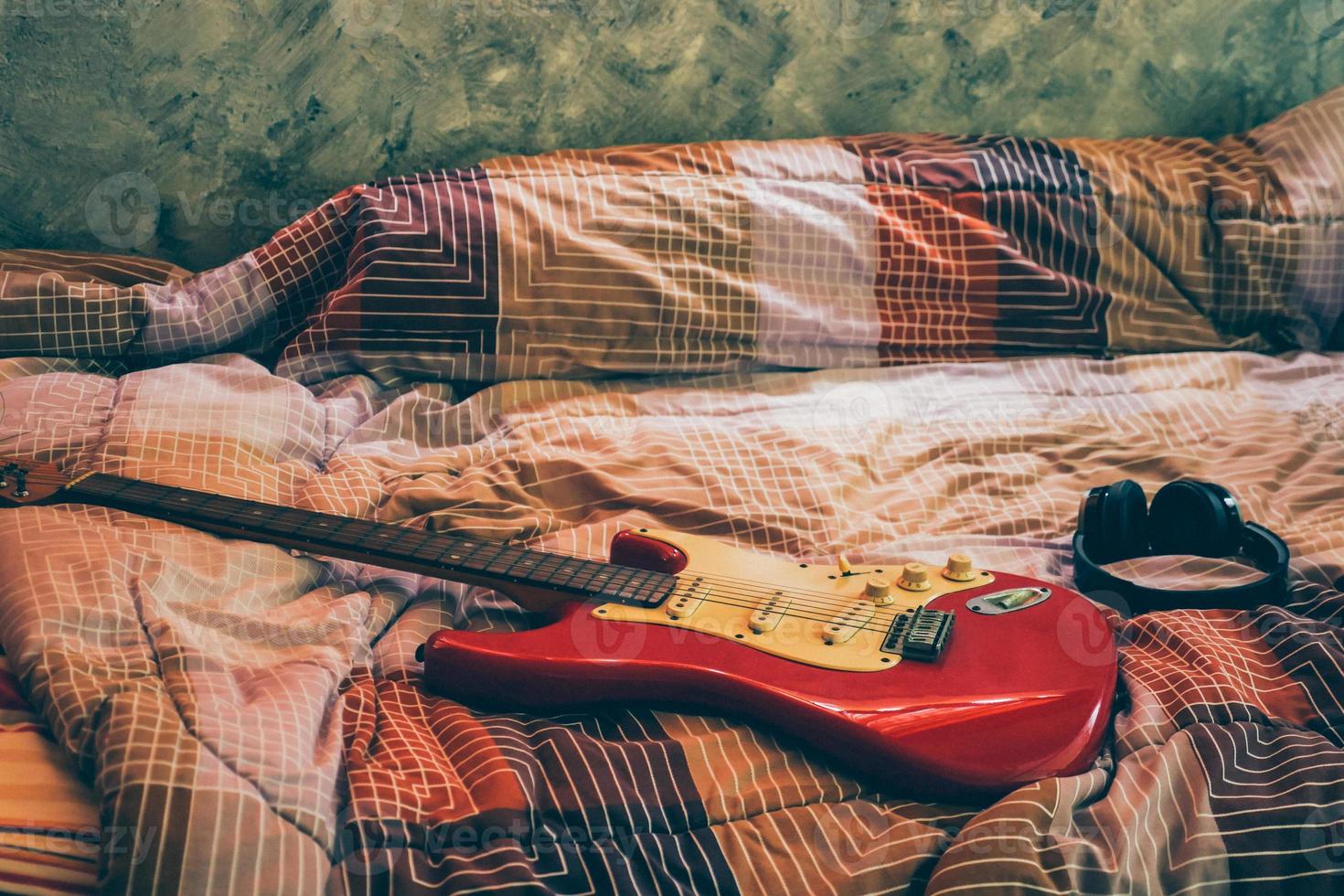 elettrico chitarra e cuffie nel Camera da letto, film grano filtro. foto