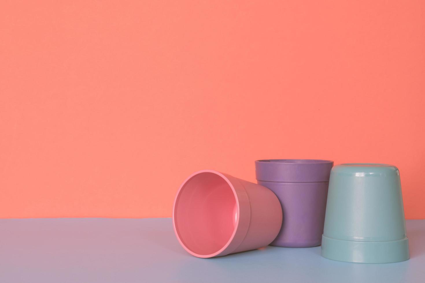 tre colore plastica tazza su pastello colori sfondo. foto