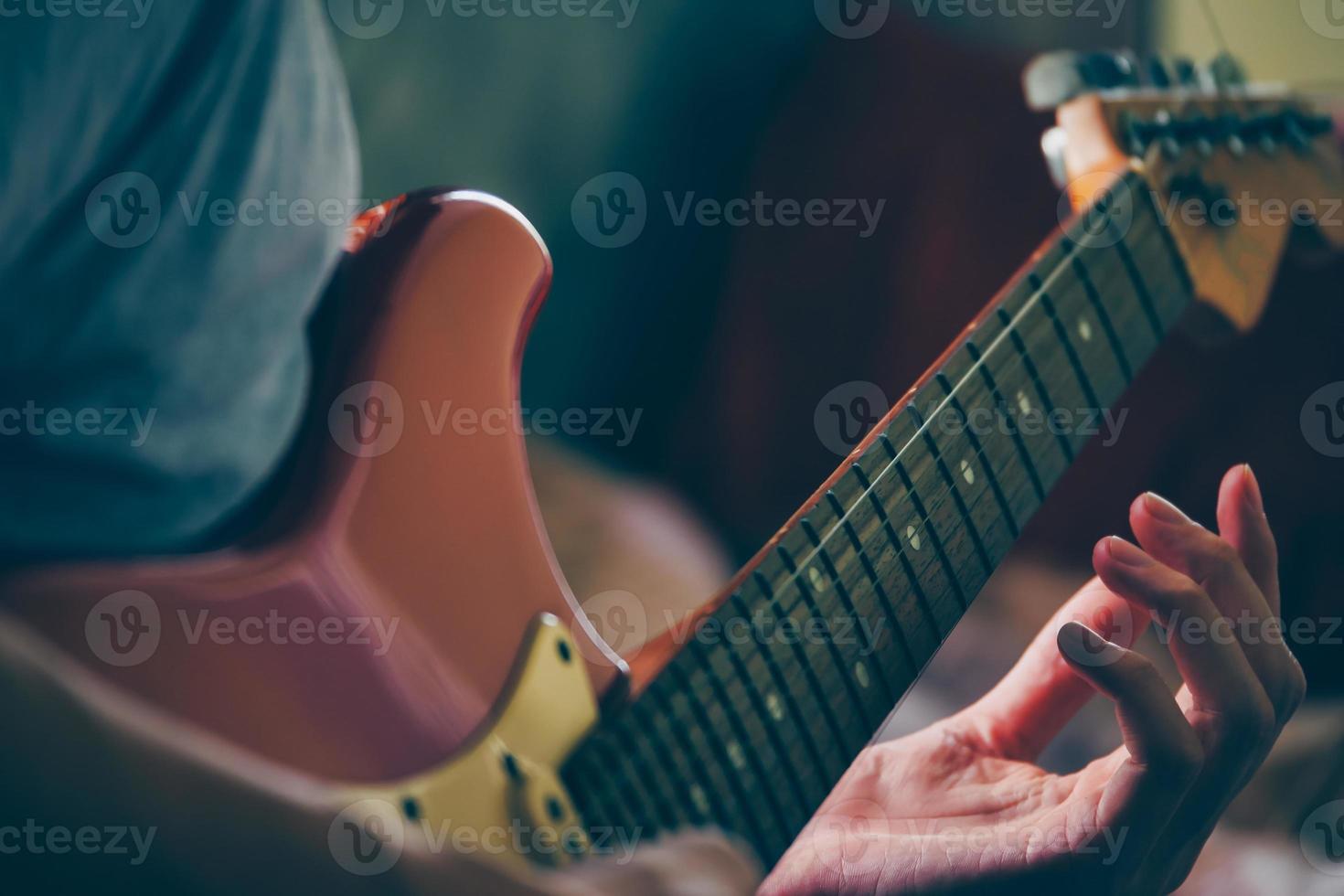 vicino su di maschio mani giocando elettrico chitarra. selettivo messa a fuoco foto