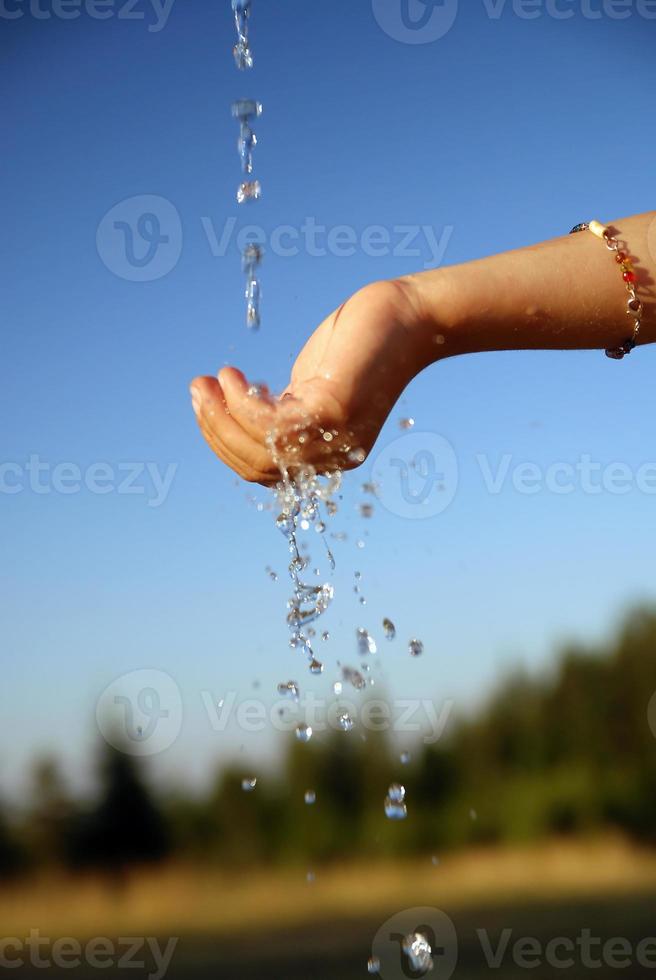 fresco acqua caduta su bambini mani foto