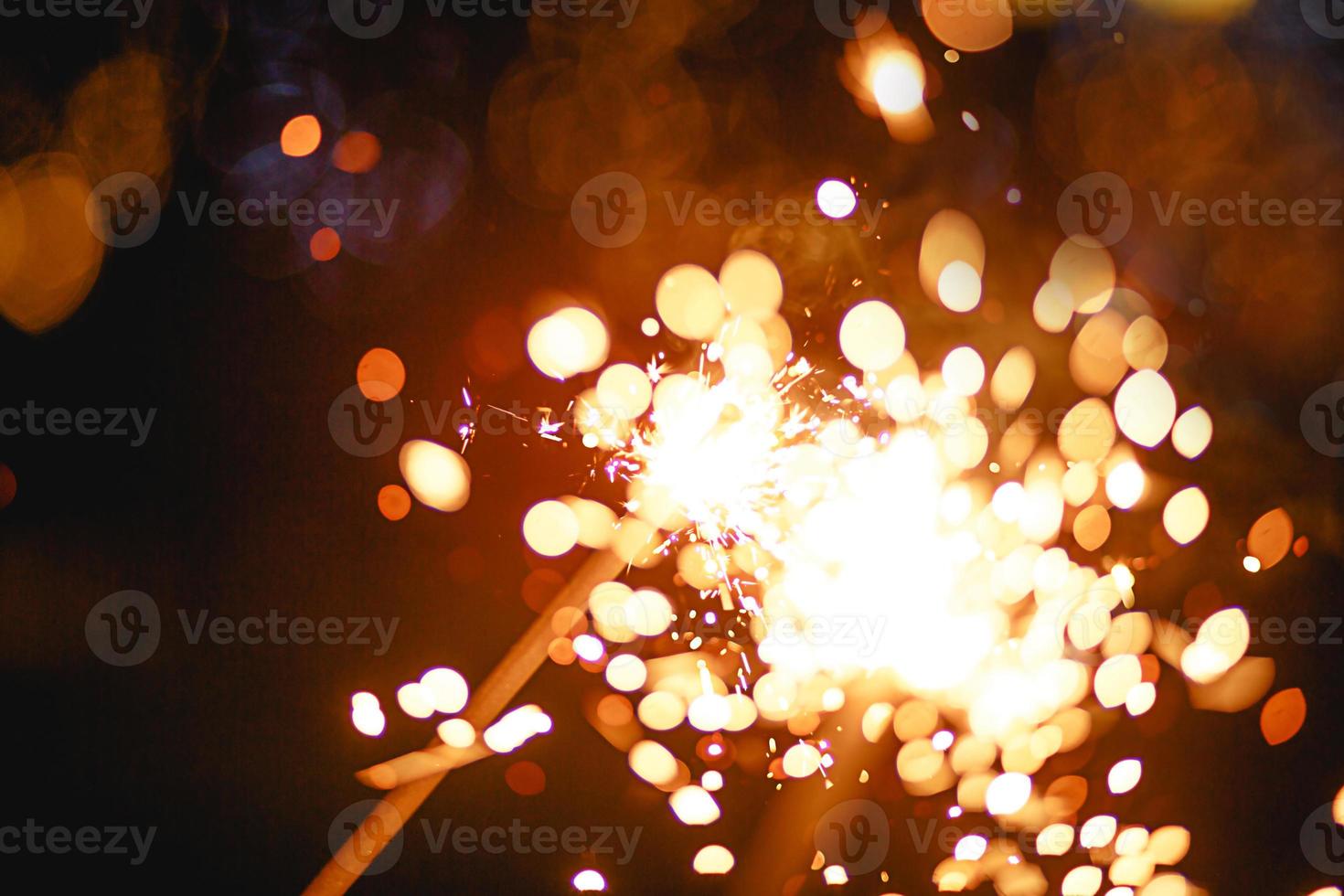 scintille e scintille nell'oscurità. trama di fuoco festivo, sfondo per capodanno e natale. foto