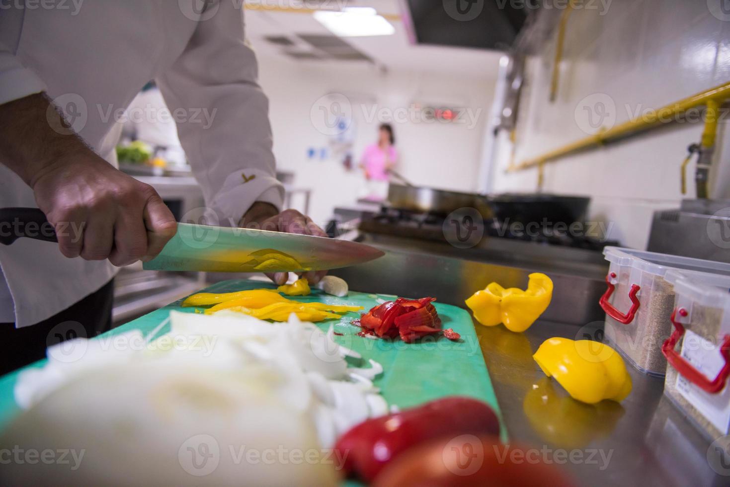 mani dello chef che tagliano verdure fresche e deliziose foto