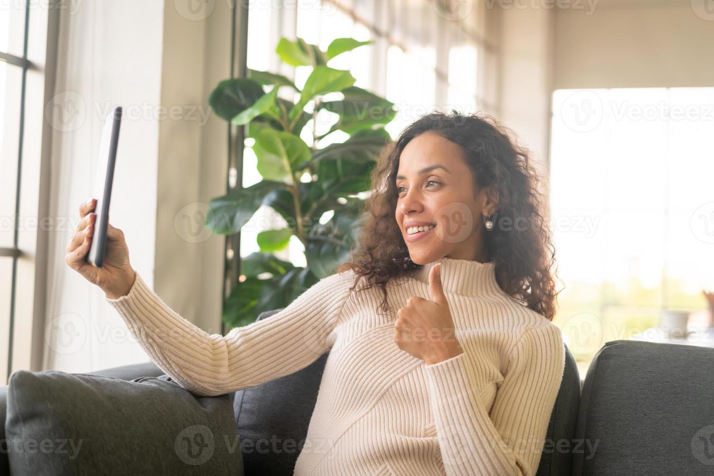 videoconferenza donna latina su tablet con sensazione felice foto