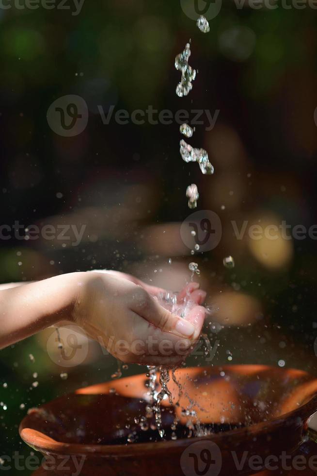 spruzzi fresco acqua su donna mani foto