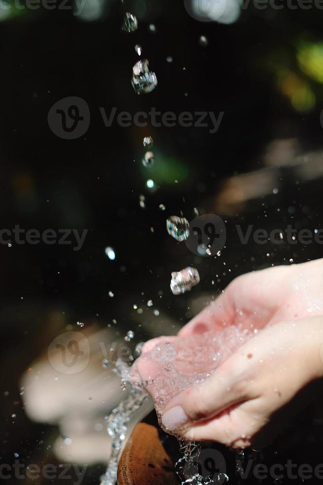 spruzzi fresco acqua su donna mani foto