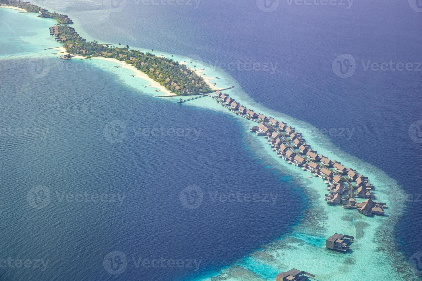 scenario paradisiaco delle maldive. paesaggio aereo tropicale, paesaggio marino con lungo molo, ville sull'acqua con splendida spiaggia di mare e laguna, natura tropicale. banner di destinazione turistica esotica, vacanze estive foto