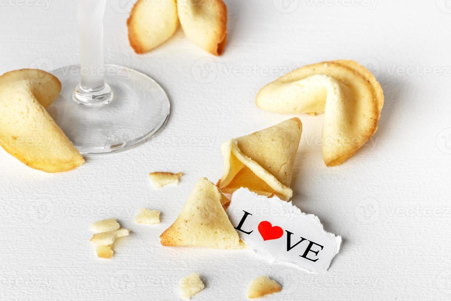 biscotti sagomato piace tortellini con il parola amore scritto su un' carta e un' bicchiere di champagne.orizzontale Immagine. foto