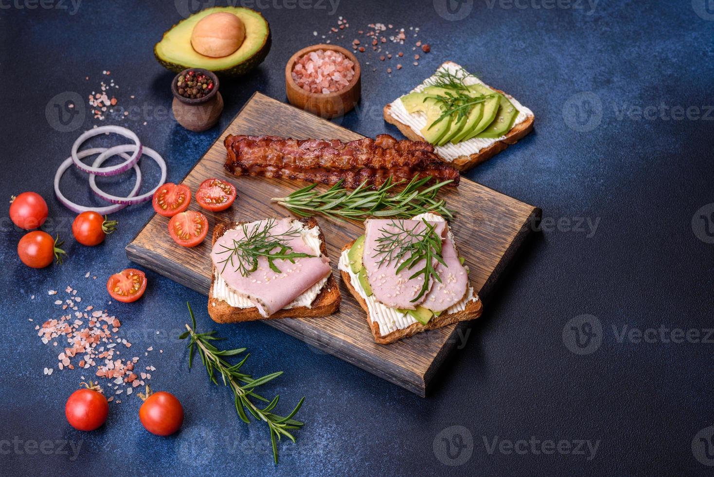 fresco, delizioso prosciutto, Burro, avocado e sesamo semi panini su un' di legno taglio tavola foto