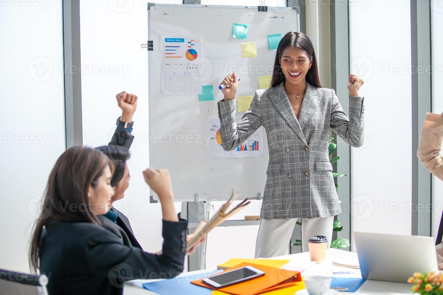 asiatico attività commerciale squadra celebrare aziendale vittoria insieme nel ufficio, ridendo e gioire, sorridente eccitato dipendenti colleghi urlando con gioia nel ufficio. foto