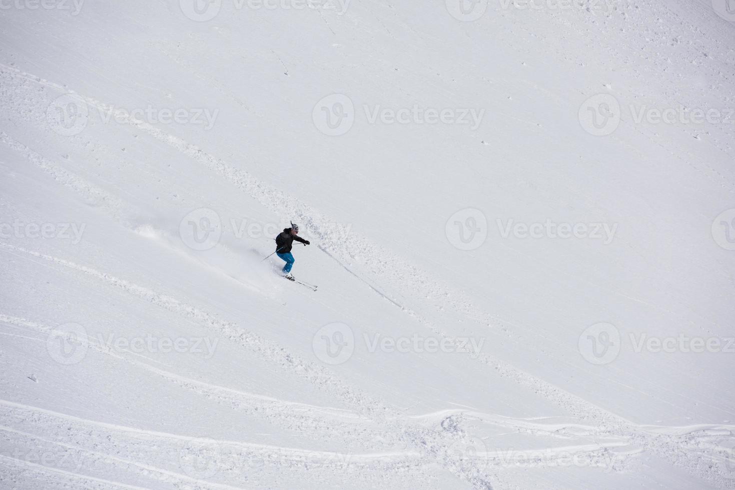 sciatore freeride che scia nella neve farinosa profonda foto