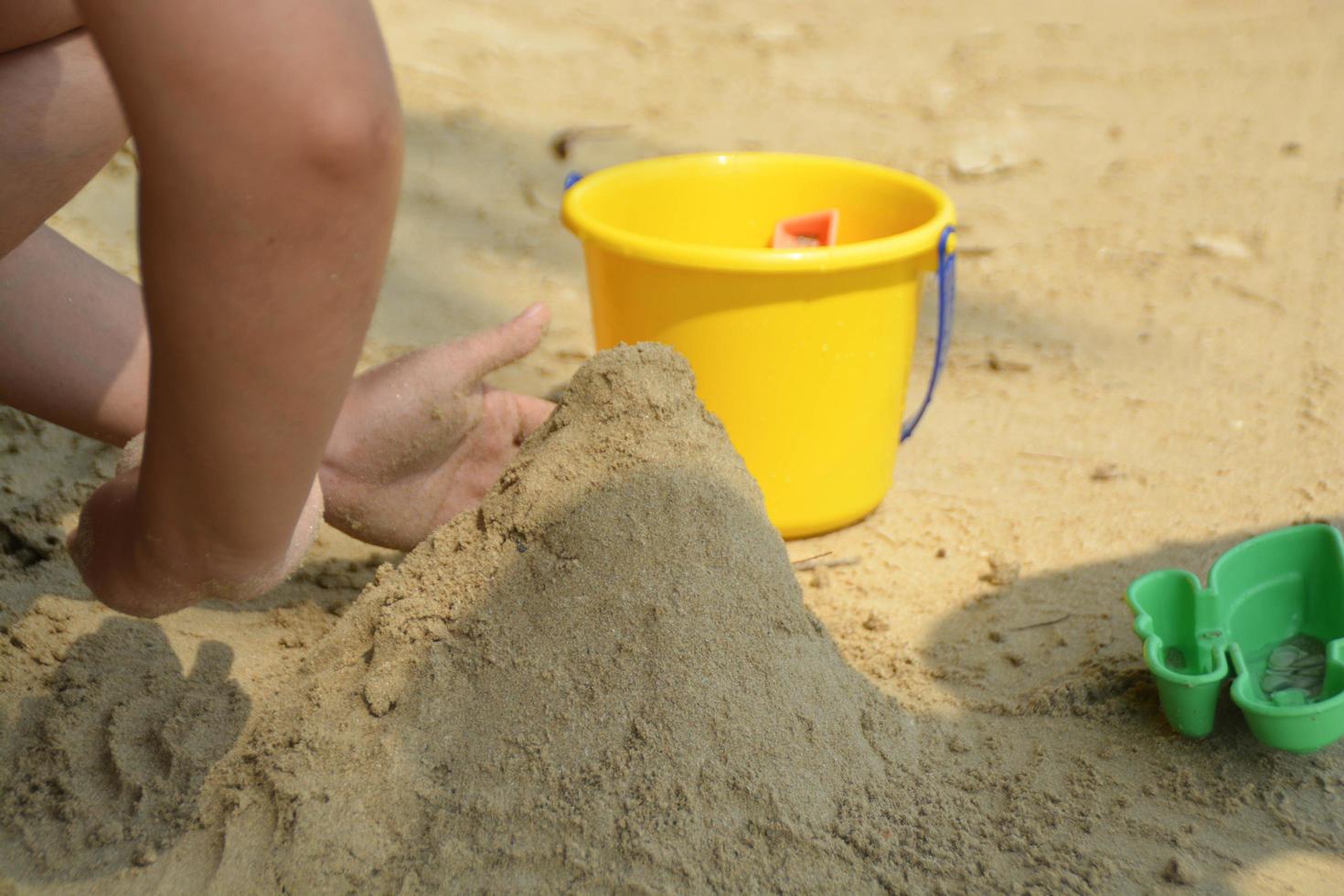 figli di edificio sabbia castello su il spiaggia foto