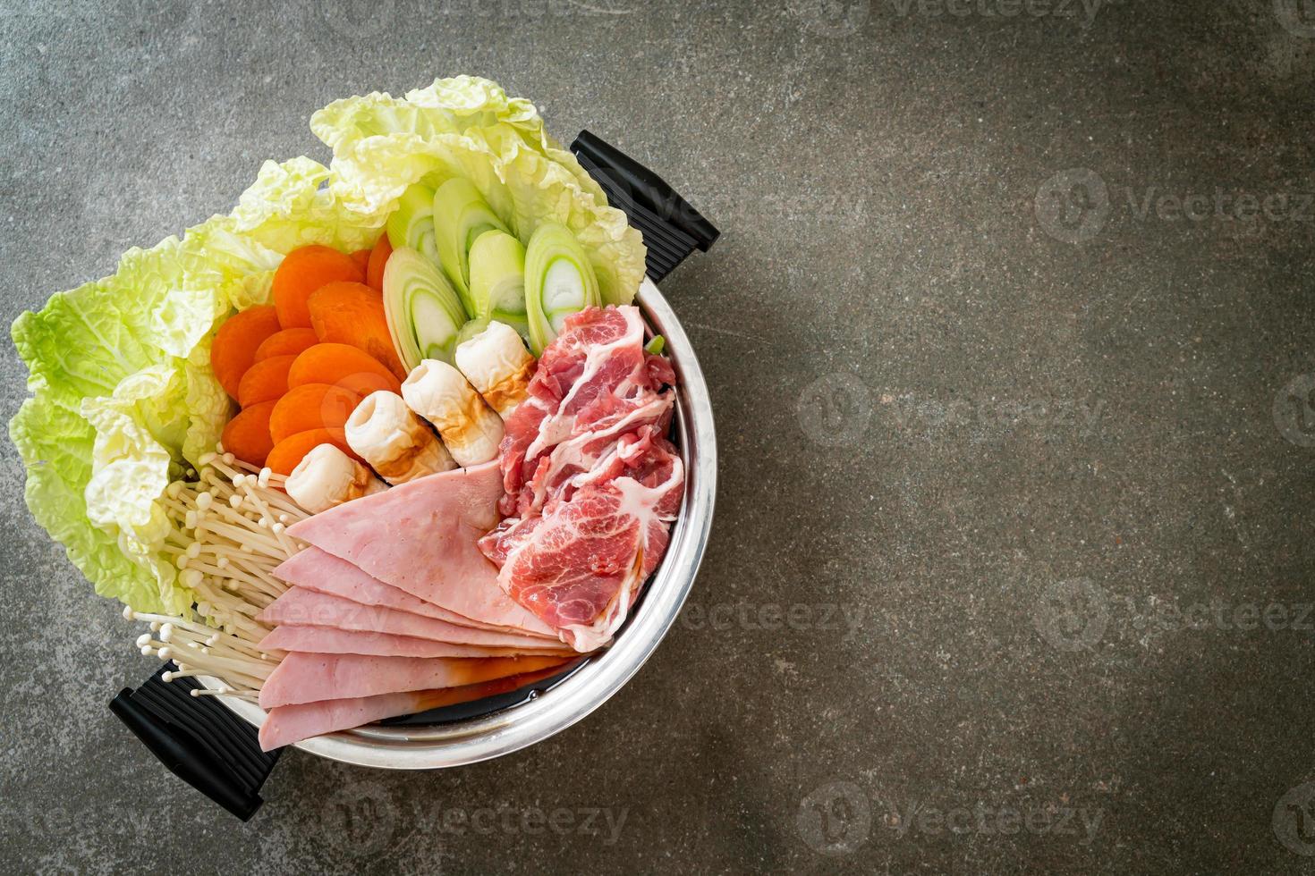 zuppa nera di sukiyaki o shabu con carne cruda e verdure foto