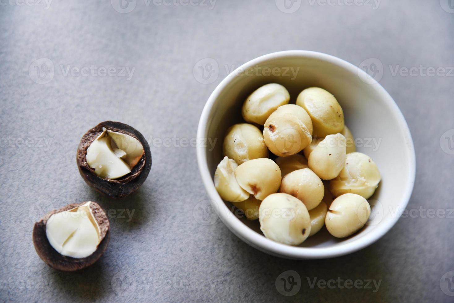 delizioso pelato macadamia Noce nel un' insalata ciotola su un' grigio sfondo. il noccioli di un' delizioso macadamia Noce avvicinamento. foto