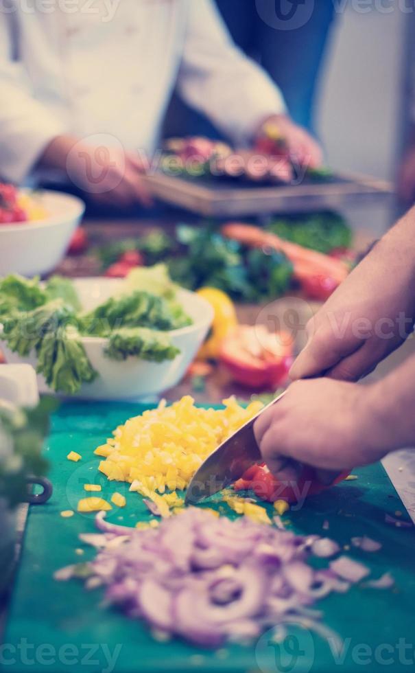 mani dello chef che tagliano verdure fresche e deliziose foto