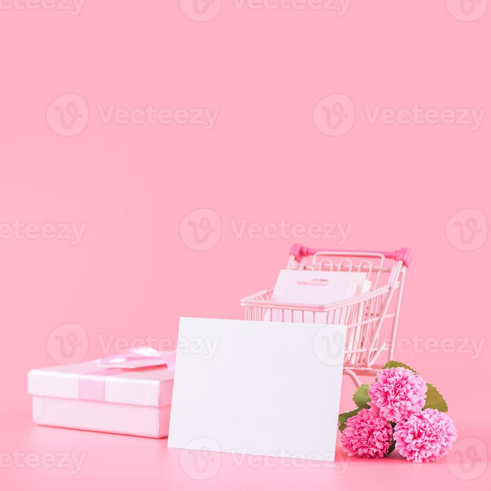 La madre di giorno, San Valentino giorno vacanza regalo design concetto, rosa garofano fiore mazzo con avvolto scatola isolato su leggero rosa sfondo, copia spazio. foto