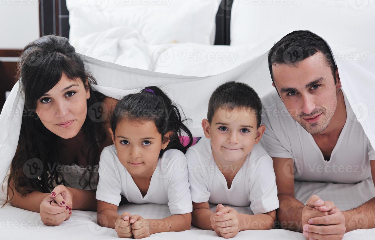 contento giovane famiglia nel loro Camera da letto foto