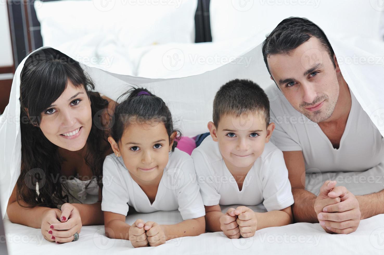 contento giovane famiglia nel loro Camera da letto foto