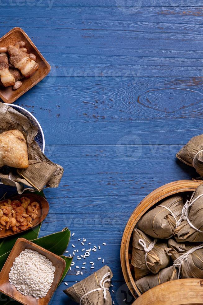 riso gnocco, zongzi - tradizionale Cinese cibo su blu di legno sfondo di Drago barca Festival, Duanwu Festival, superiore Visualizza, piatto posare design concetto. foto