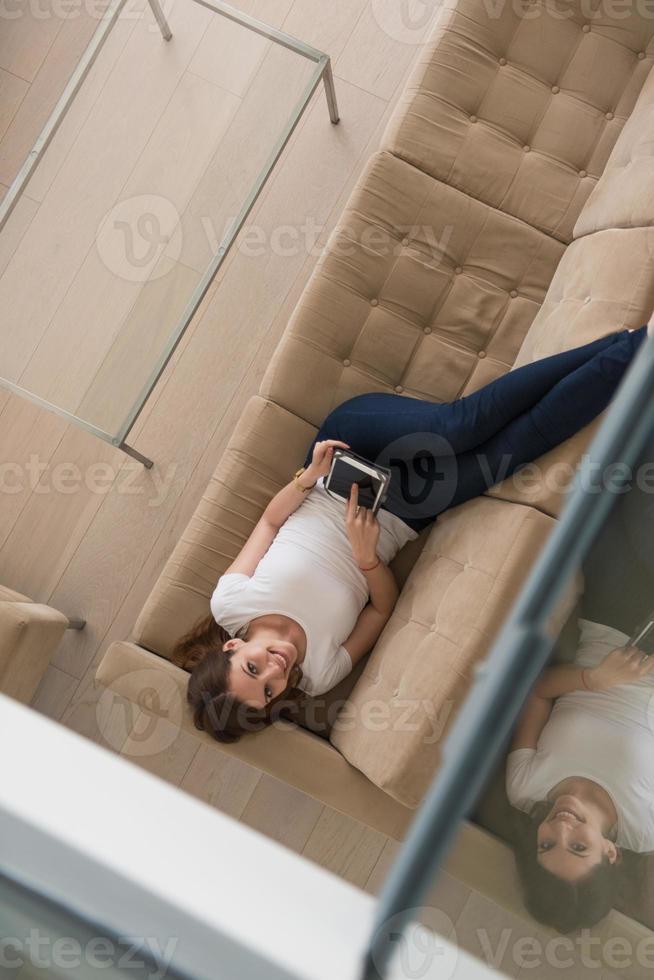 donna su divano utilizzando tavoletta computer foto
