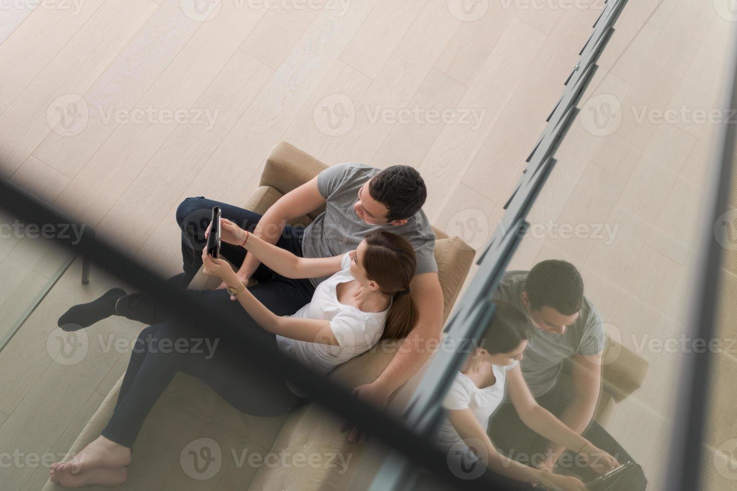 coppia che si rilassa a casa con i tablet foto