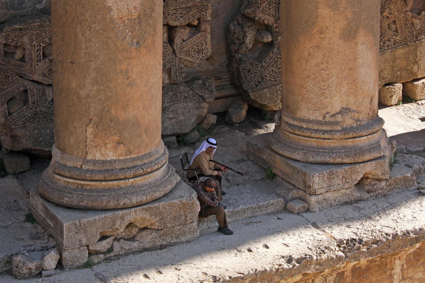 baalbek, Libano, 2017 - Due uomini rilassare nel il ombra di romano rovine nel baalbek, Libano foto