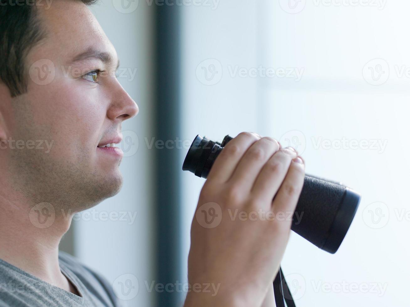 uomo guardare con binocolo foto