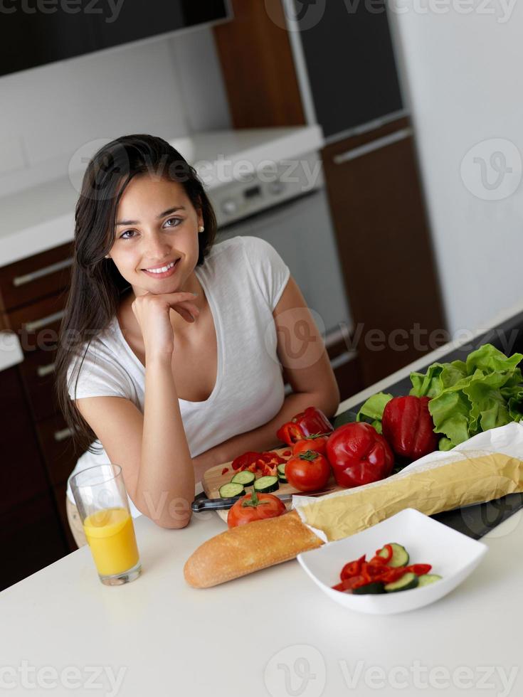 giovane donna che cucina in cucina foto