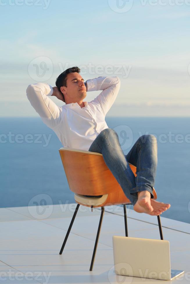 rilassato giovane uomo a casa su balcone foto