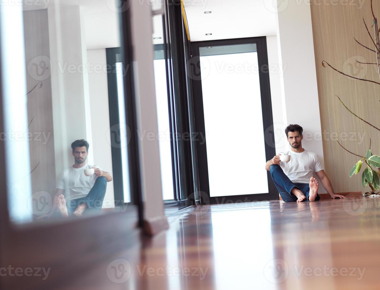 rilassato giovane uomo bevanda primo mattina caffè foto