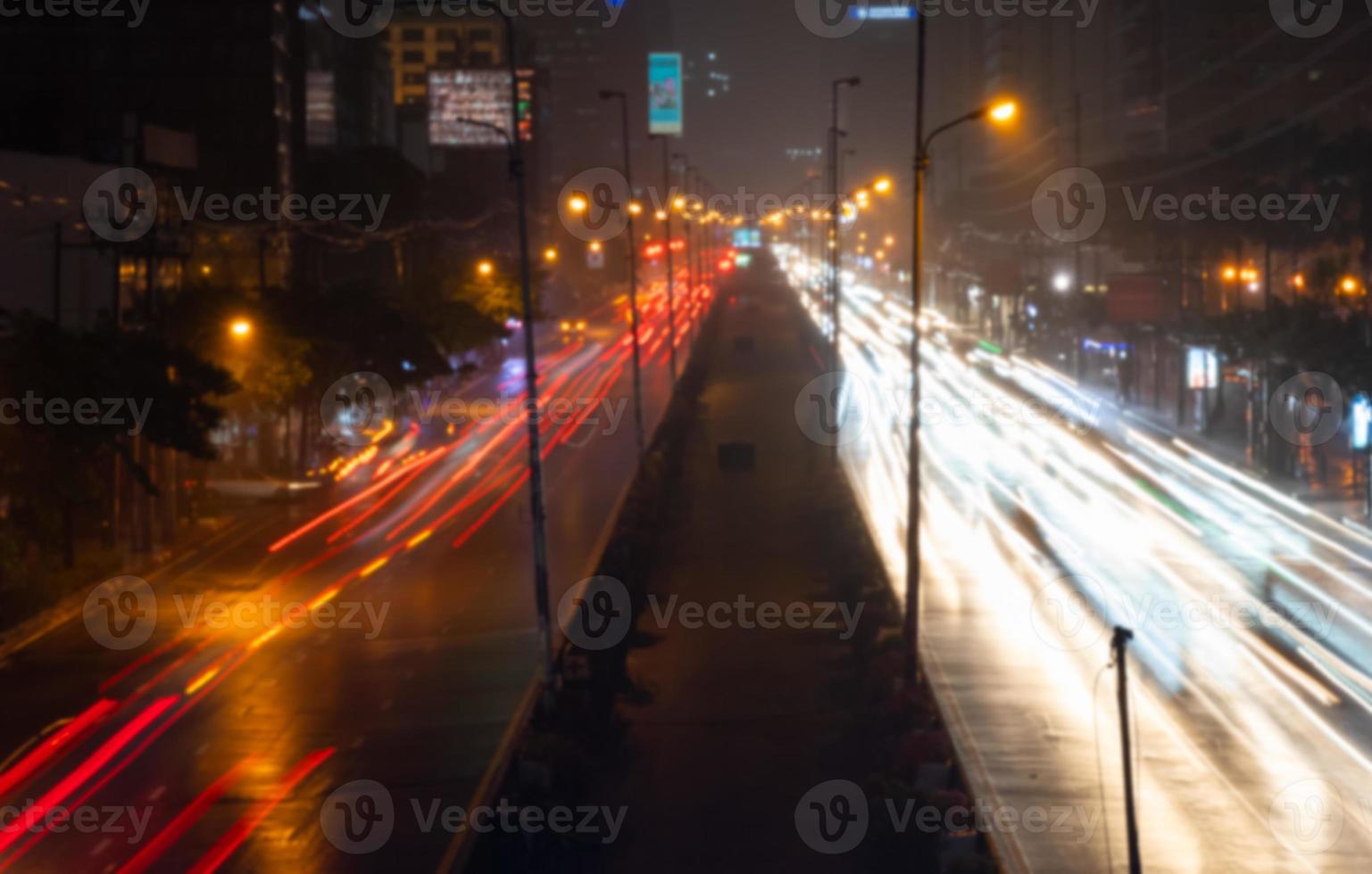 sfocato immagine di paesaggio urbano di bangkok a notte con traffico marmellata nel piovoso giorno foto