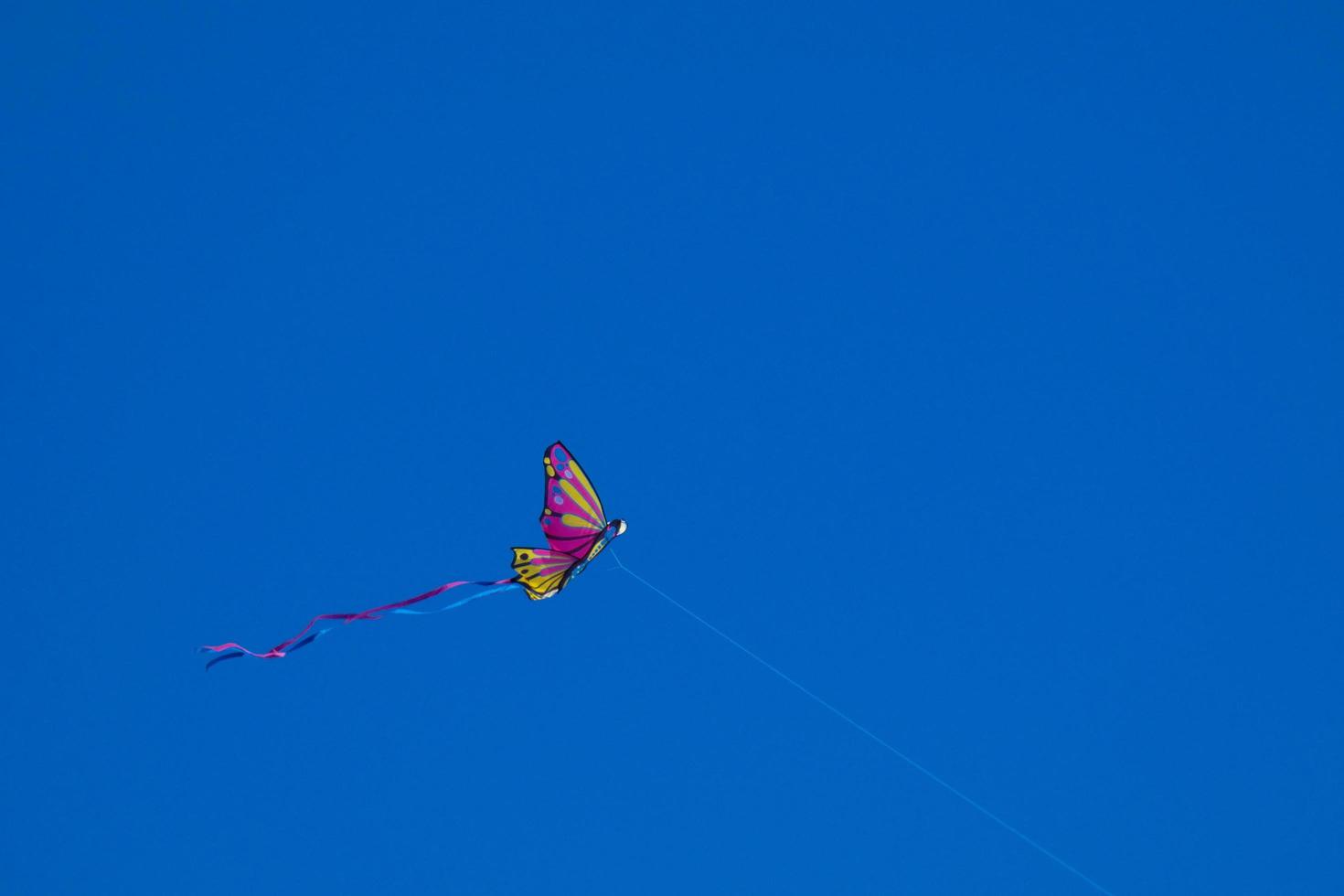 colorato aquilone volante sotto il blu cielo foto