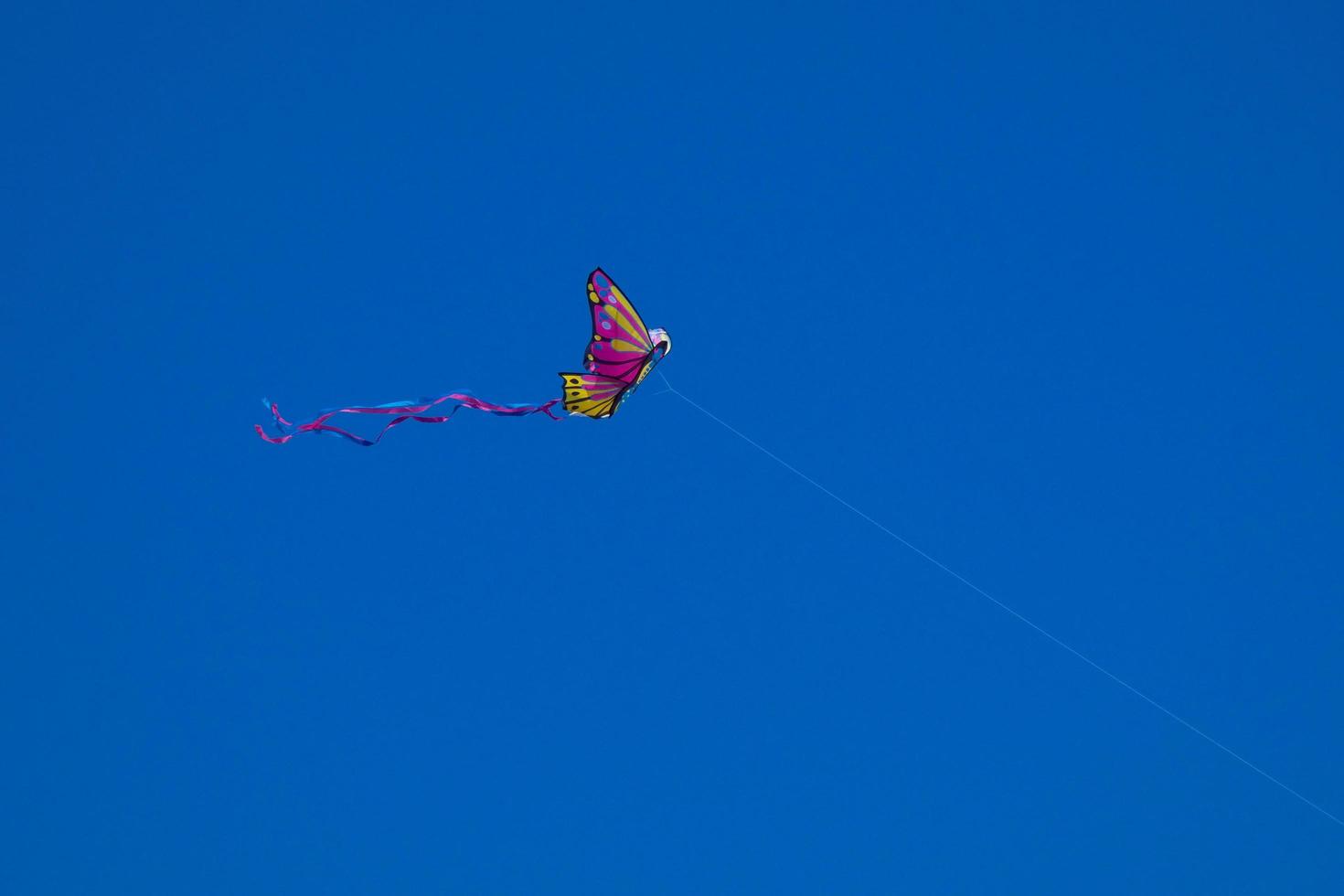 colorato aquilone volante sotto il blu cielo foto